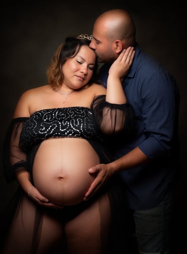 a pregnant woman is holding her belly while a man kisses her belly