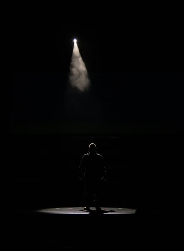 a man standing in front of a spotlight light
