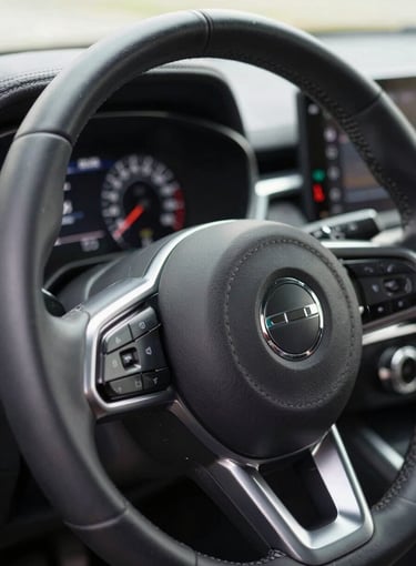 Macro shot of a modern leather-wrapped steering wheel and digital dashboard safety indicators, bright neutral daylight, clean reflections.
