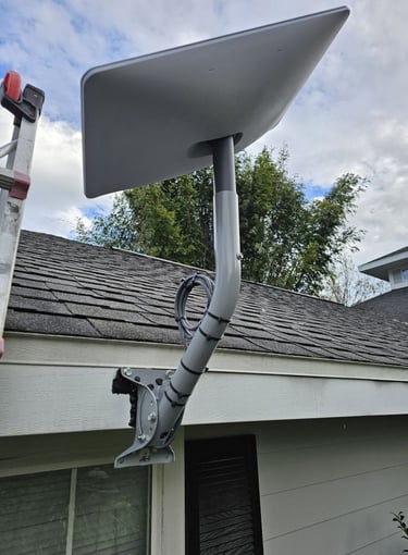 A Starlink satellite internet dish mounted on a residential roof using a wall pivot mount.