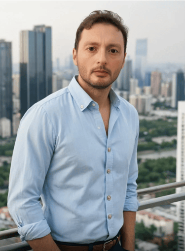 a man in a blue shirt and jeans standing in front of a cityscape