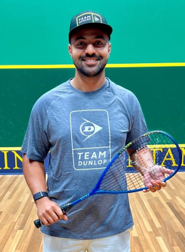 a man in a blue shirt and white shorts holding a tennis racket