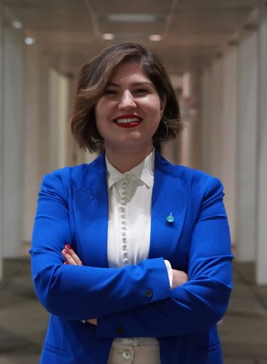 Blue Pen education consultant founder in a blue blazer and white blouse, smiling with arms crossed