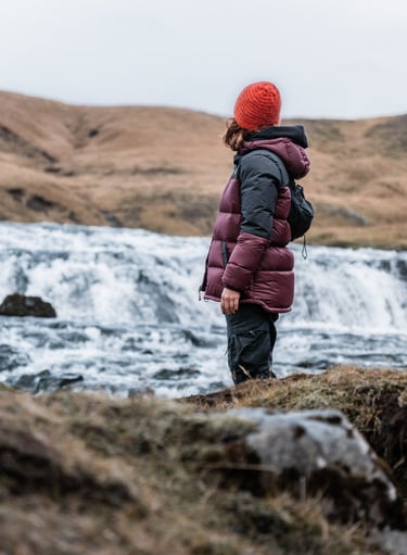a person standing on a hill with a backpacker