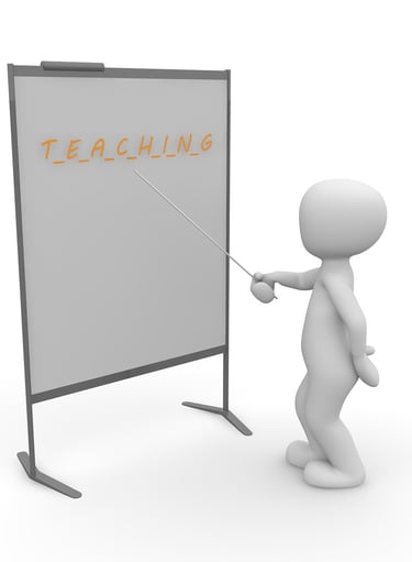 Solhouette pointing to a white board with a pointer stick with Teaching written on the board