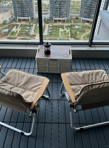Small balcony garden with compact furniture, green plants, and warm decor for comfortable outdoor li