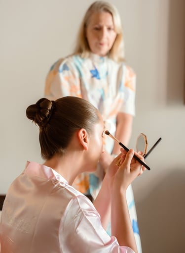 a woman in a pink robe is getting ready to be a bridesmaid
