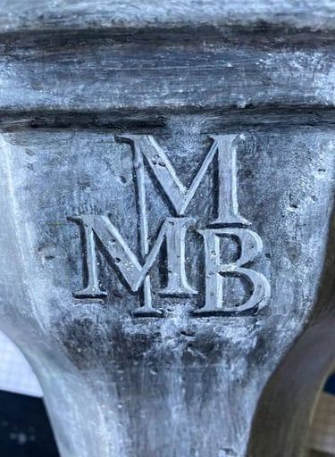A monogram painted in trompe-l'oeil style as if embossed into lead.