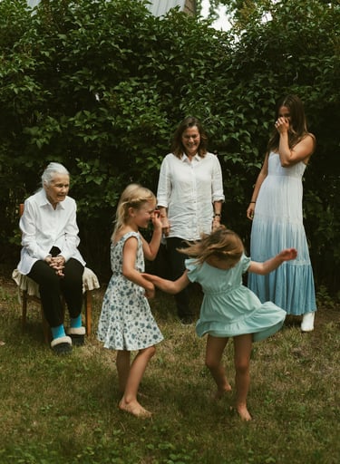 a family gathering in a backyard with a young girl playing with a frisbee