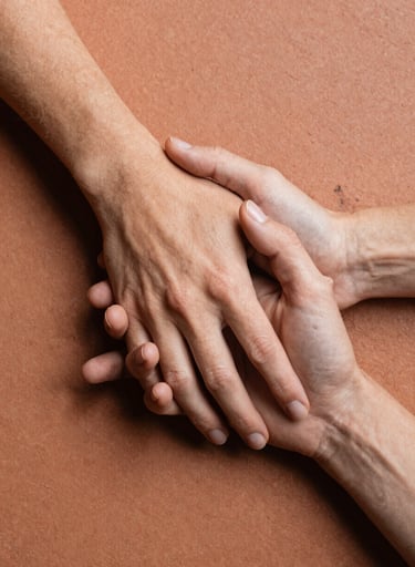 A detailed shot of Sarah and Tom's hands intertwined, resting on a textured terracotta surface. The lighting is natural and inviting, emphasizing the authentic human connection.