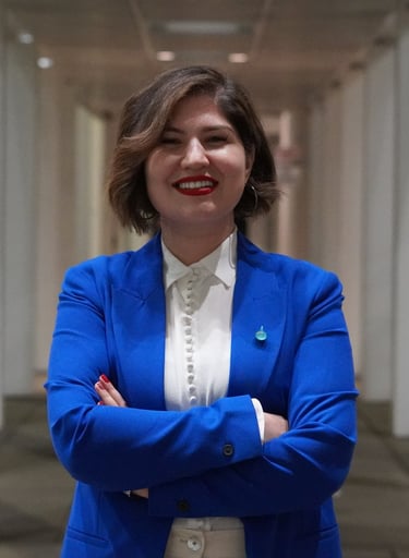 Blue Pen education consultant founder in a blue blazer and white blouse, smiling with arms crossed