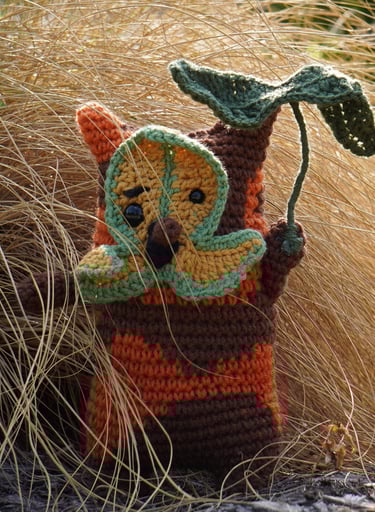 A korok holding a leaf standing in a bush.