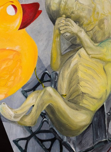 Painted yellow baby duck looking at the greenish fetus peeking through & sitting on the park bench.