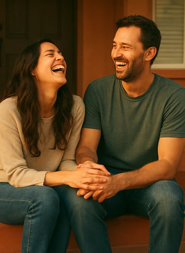 A candid lifestyle photograph of a couple sharing a genuine laugh on a terracotta-colored porch, authentic connection, warm late-afternoon sunlight, North American home setting.