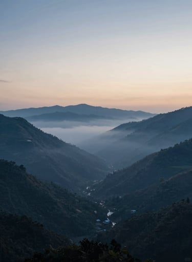 A wide-angle landscape shot of a misty valley at dawn, captured with a deep cinematic feel. The cool blues of #1A2F3C transition into a soft #F5F2EC sky, symbolizing a new beginning and spiritual awakening.
