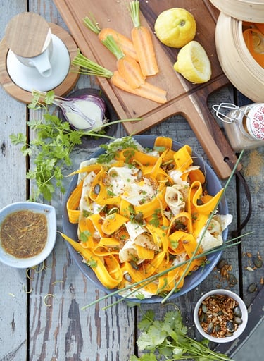 a plate of pasta with vegetables and sauce
