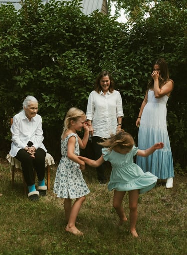 a family gathering in a backyard with a young girl playing with a frisbee