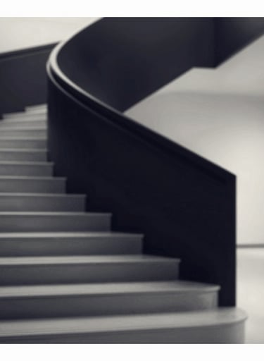 A high-contrast black and white shot of a modern staircase, evoking a sense of structure and design precision. The shadows are deep navy #0D1B2A, and the highlights are crisp #E0E1DD.