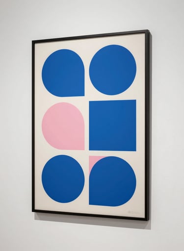 An artistic eye-level photograph of a large, framed Bauhaus-style poster hanging on a white wall in a gallery in New York. The poster features bold circles and squares in cerulean blue and soft pink. Clean, minimalist composition.
