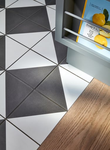 Black and white floor tiles laid in a diamond pattern with oak wood flooring