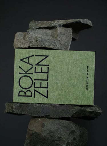 a box of boka fragrance with a bookmark on it and a stack of rocks