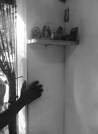 Mauritian home interior with hand on wall beside a small shrine, Cape Town Photography Festival 2025.