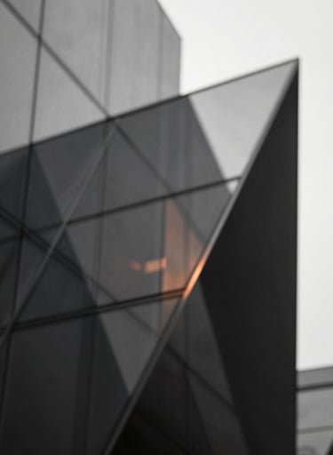 Abstract architectural composition of intersecting planes and glass. Tones of #333333 and #F9F7F2 with a subtle warm accent in #BC6C47 reflecting on the glass surfaces.