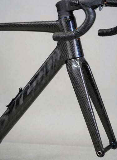 Detailed shot of a carbon fiber racing bicycle frame showing sharp geometric patterns and sophisticated engineering, professional lighting, charcoal black and steel blue palette, Western / International context.