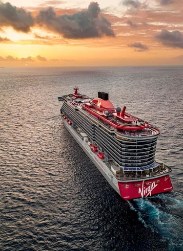 Virgin Voyages cruise ship sailing on the ocean into the sunset
