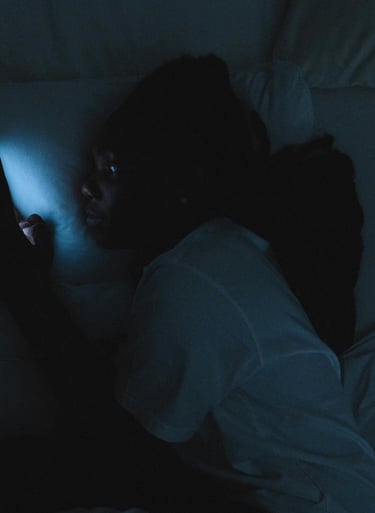a person laying in bed with a cell phone