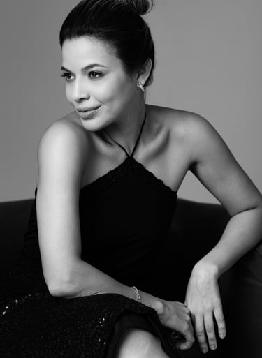 a woman in a black dress sitting on a couch retratos fotografia em estudio São Luís ensaio