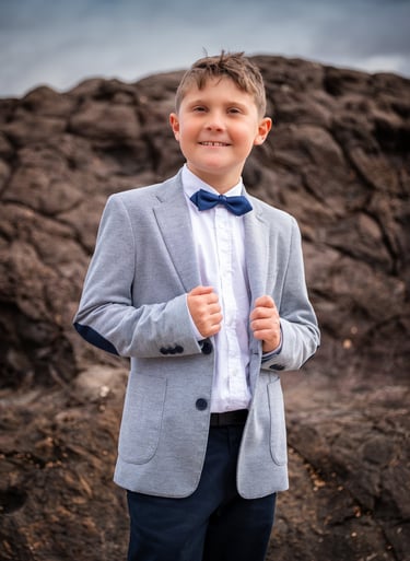 a young boy in a suit and bow tie