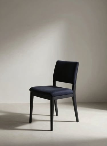 A minimalist photography shot of a single dark navy chair in a vast off-white room. Dramatic side lighting, high contrast, elegant and curated mood, Global / General interior.