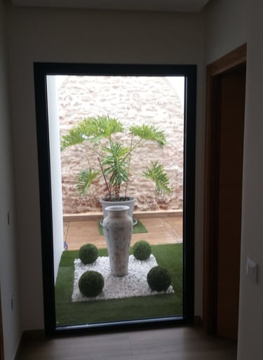 Ventana fija con plantas al fondo.