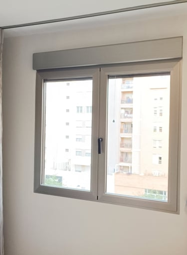 Ventana de aluminio plata con cajón de persiana.