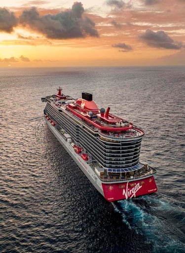 Virgin Voyages cruise ship sailing on the ocean into the sunset