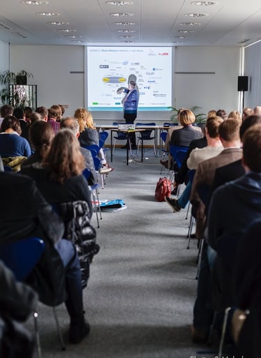 Ein Mann, der während einer CBMI-Konferenz eine PowerPoint-Präsentation hält.