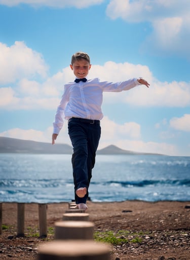 a young boy is walking on a wooden platform