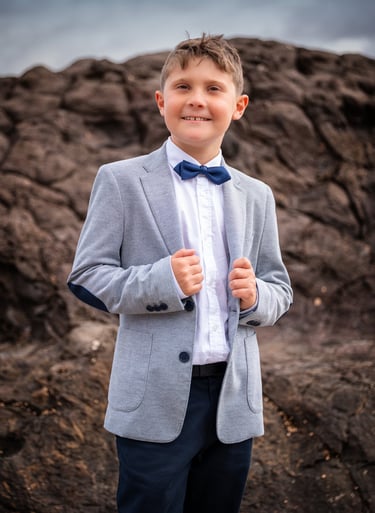 a young boy in a suit and bow tie