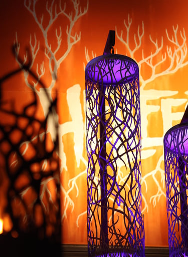 a group of three tall purple lanterns with birds on them