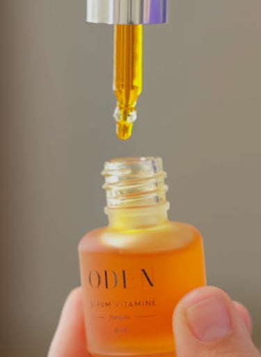 a person holding a bottle of liquid cosmetic  in their hand