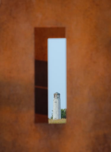 A lighthouse shot through an bronze urban sculpture. Framing looks cool.