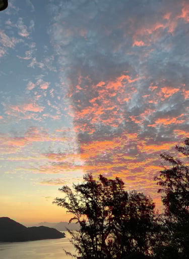 a sunset sky with a cross - country road sign