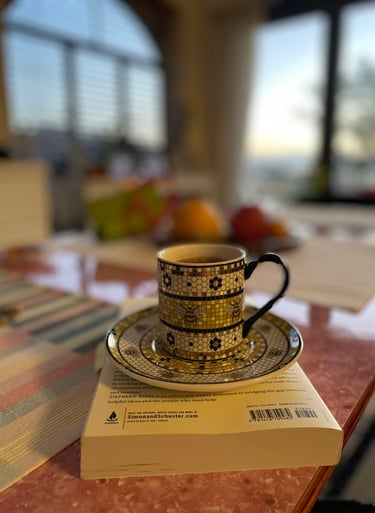 a cup of coffee and a book on a table