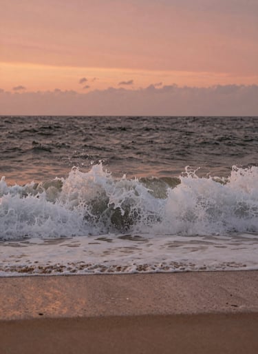 Detail shot of waves crashing on a North American / US beach at sunset. Warm terracotta and soft sand colors in the water and sky. Cinematic and serene.