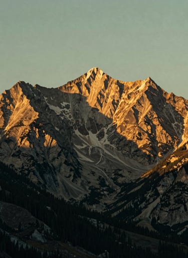 Golden hour sunlight hitting the rugged peaks of a North American / US mountain range, muted gold and sage green tones, cinematic lighting, serene landscape photography.