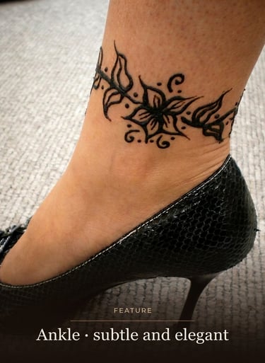 Elegant floral henna tattoo design around a woman's ankle wearing a black high heel shoe.