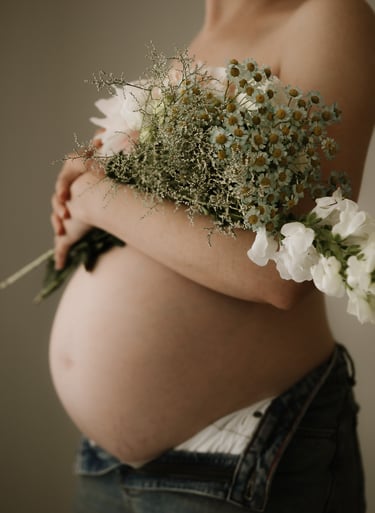pregnant belly holding flowers taken in studio, Adelaide