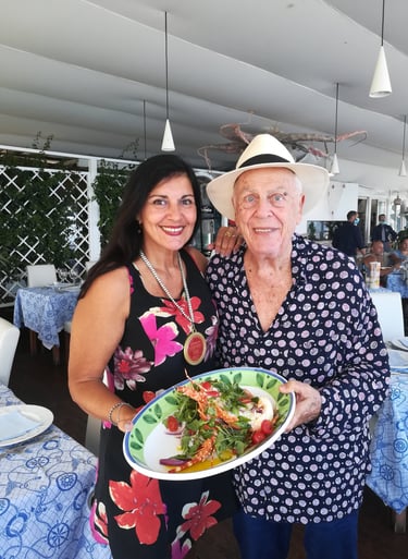 Clara Mennella con il Professor Aldo Palmeri del Club Corone Oro Sicilia, mentre presentano un piatto gourmet in un ristorant