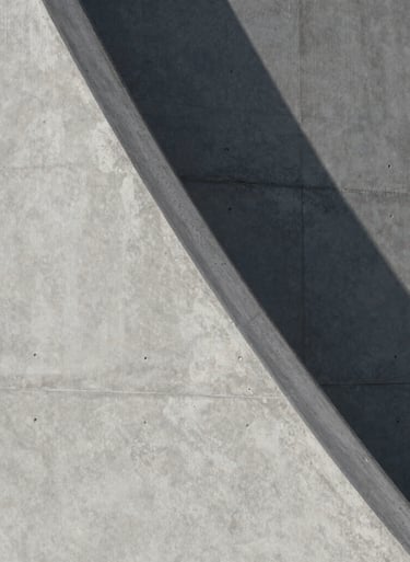 Close-up of architectural textures featuring smooth concrete and sharp shadows. Minimalist and sophisticated composition in gray tones. International / Professional.